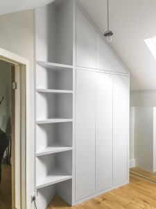 A huge contemporary style fitted wardrobe with sloping ceiling