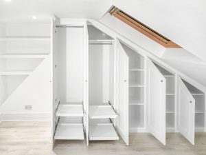 Traditional sloping wardrobe and floating shelves fitted in the loft spare room