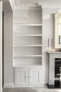 Alcove fitted TV cabinets with bookshelves besides the chimney