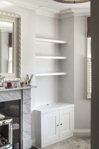 Alcove fitted TV cabinets with bookshelves besides the chimney