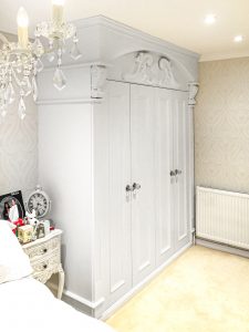 A gorgeous wardrobe with nice wood-carved corbels and French rosette. Wooden cornice, skirting, fluted panels, beaded and mirrored doors with metallic knobs