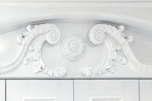 A gorgeous wardrobe with nice wood-carved corbels and French rosette. Wooden cornice, skirting, fluted panels, beaded and mirrored doors with metallic knobs