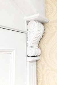A gorgeous wardrobe with nice wood-carved corbels and French rosette. Wooden cornice, skirting, fluted panels, beaded and mirrored doors with metallic knobs