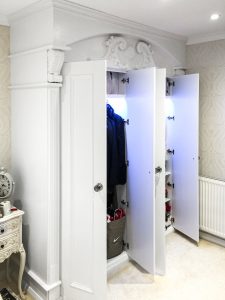 A gorgeous wardrobe with nice wood-carved corbels and French rosette. Wooden cornice, skirting, fluted panels, beaded and mirrored doors with metallic knobs