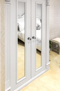 A gorgeous wardrobe with nice wood-carved corbels and French rosette. Wooden cornice, skirting, fluted panels, beaded and mirrored doors with metallic knobs