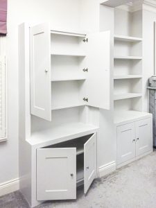 Alcove fitted TV cabinets with bookshelves besides the chimney