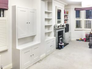 Alcove fitted TV cabinets with bookshelves besides the chimney