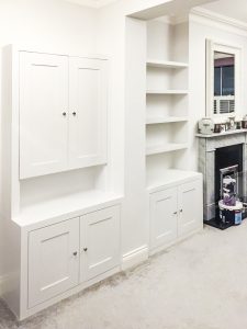 Alcove fitted TV cabinets with bookshelves besides the chimney