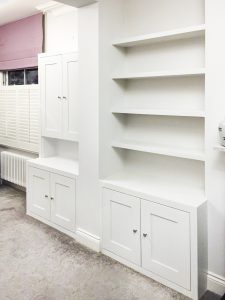 Alcove fitted TV cabinets with bookshelves besides the chimney